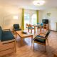 Wohnzimmer mit Sofa, Sesseln, Esstiwsch und Fernseher