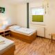 Schlafzimmer / Kinderzimmer mit zwei Einzelbetten, Nachttischen, Stuhl und weißer Bettwäsche