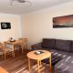 Wohnzimmer mit Esstisch, grauem Sofa und holz-Sofatisch
